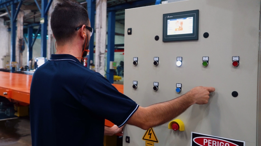 Colaborador operando painel de comando com IHM