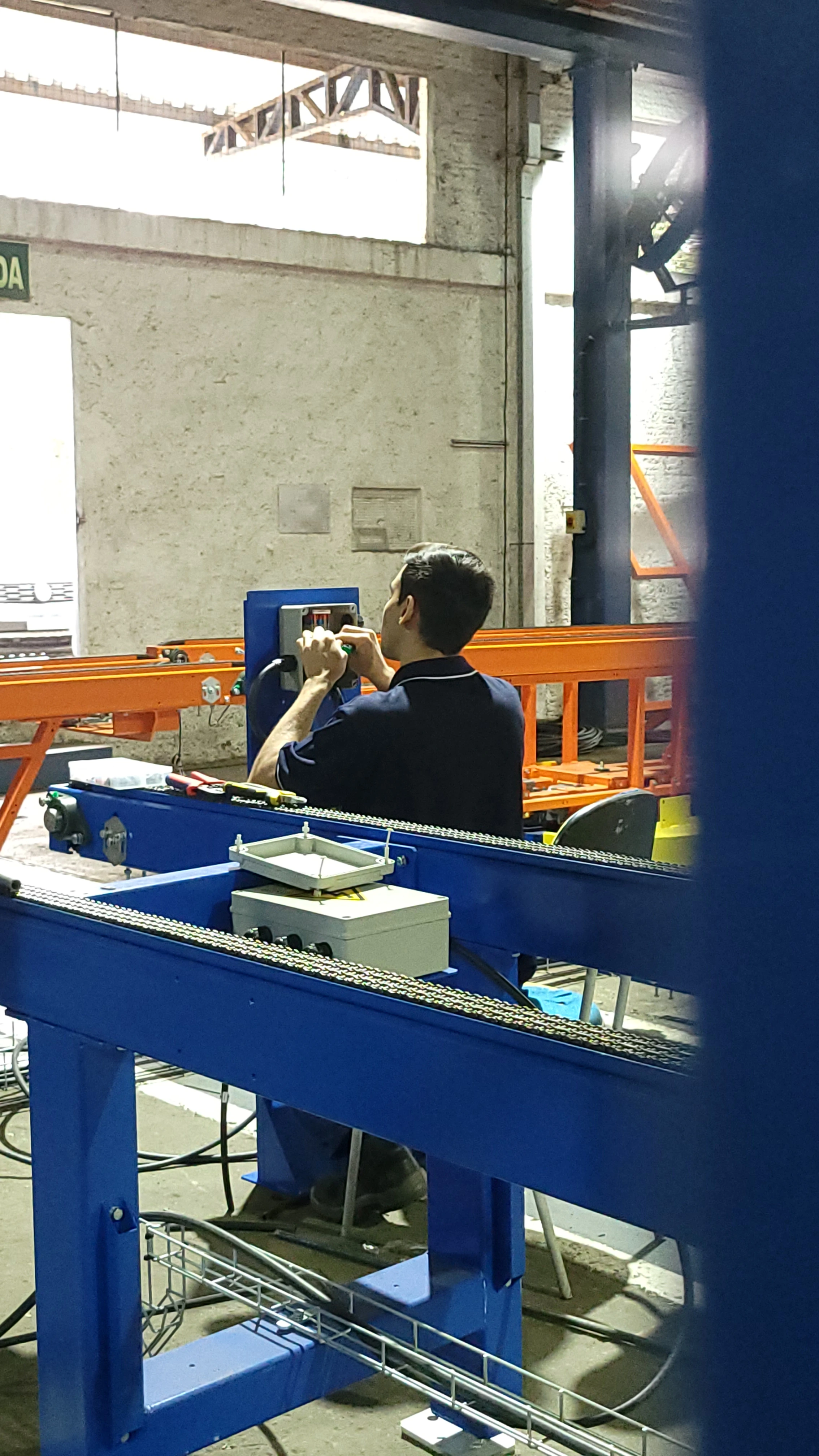 Colaborador em esquema elétrico de linha de montagem